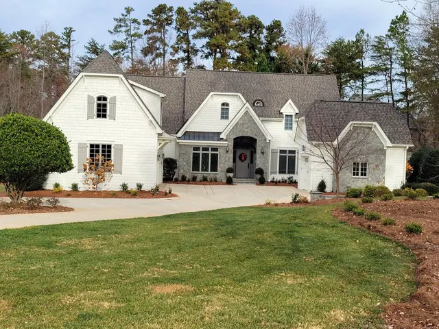 A large white house with a lush green lawn in front of it