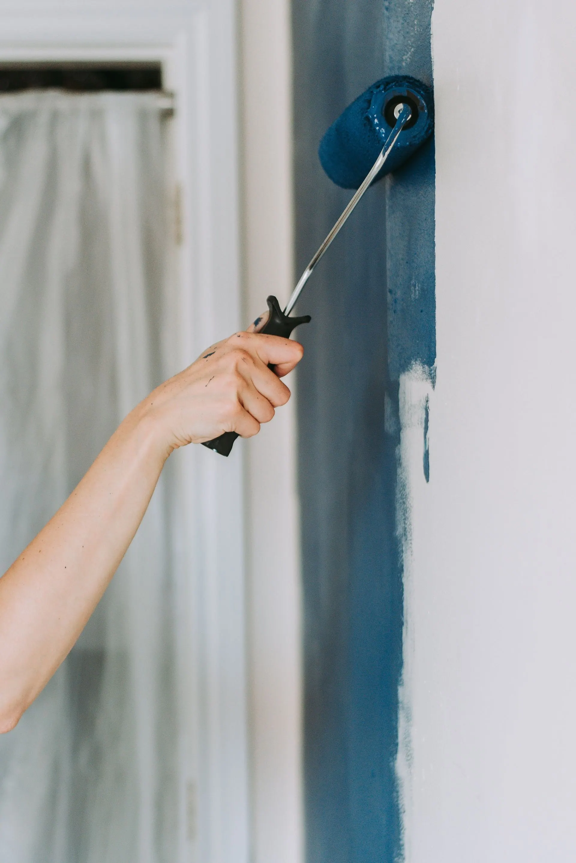 A man is installing a drywall ceiling in a room.