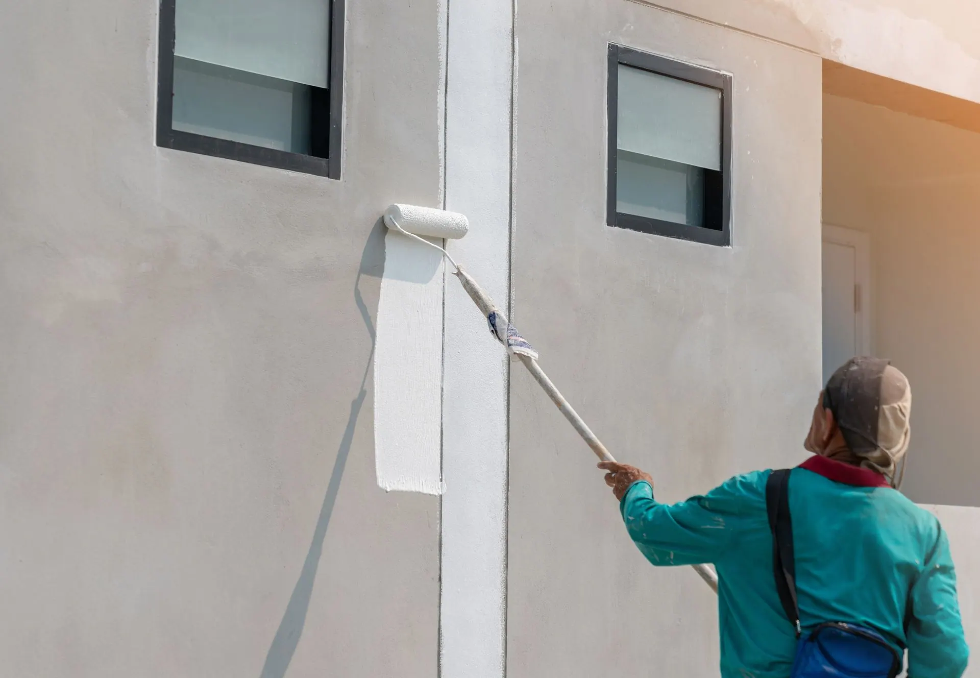 A house is being painted with buckets of paint and a ladder.
